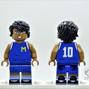 May include: A blue and white basketball jersey with the letter "M" on the front and the number "10" on the back. The jersey is worn by a Lego minifigure with black hair and brown skin.