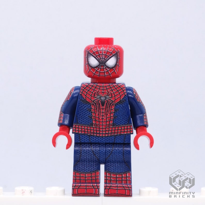 K&ouml;nnte beinhalten: Eine Lego-Minifigur von Spider-Man. Der Kopf und die H&auml;nde sind rot, mit einem Spinnennetz-Muster. Der Torso und die Beine sind blau mit einem roten Spinnennetz-Design. Der Hintergrund ist wei&szlig;.