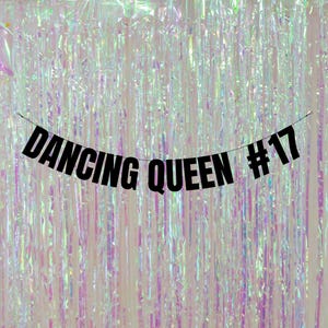 May include: Black banner with the text "Dancing Queen #17" hanging against a shimmering iridescent background.