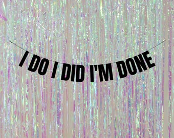 May include: Black and white banner with the text "I DO I DID I'M DONE" hanging against a shimmering iridescent background.