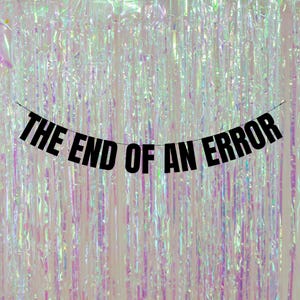 May include: Black banner with the text "THE END OF AN ERROR" hanging against a shimmering iridescent background.