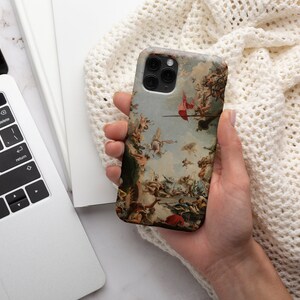 Puede incluir: Una funda para tel&eacute;fono con una pintura vintage de una escena de batalla. La funda est&aacute; hecha de pl&aacute;stico duro y tiene una parte posterior transparente. La pintura est&aacute; en tonos de marr&oacute;n, rojo y blanco.