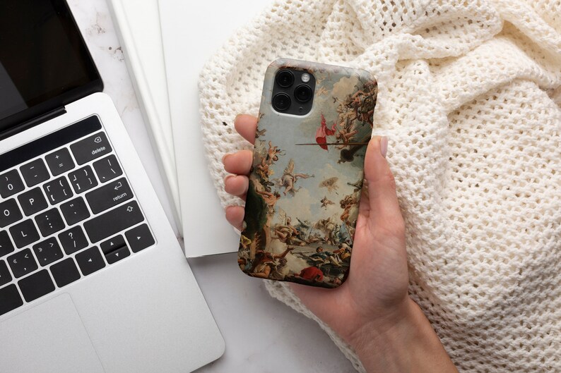 Puede incluir: Una funda para tel&eacute;fono con una pintura vintage de una escena de batalla. La funda est&aacute; hecha de pl&aacute;stico duro y tiene una parte posterior transparente. La pintura est&aacute; en tonos de marr&oacute;n, rojo y blanco.