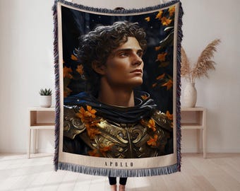Puede incluir: Una manta tejida con un retrato de un hombre con armadura dorada, con la palabra "APOLLO" en la parte inferior. La imagen tiene un fondo oscuro con hojas naranjas. La manta tiene un borde con flecos.