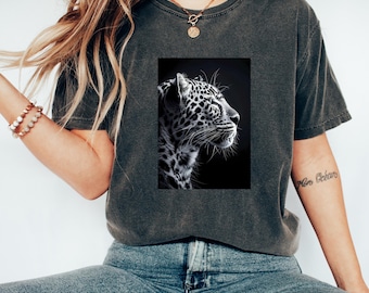 May include: A dark gray t-shirt with a black and white image of a leopard's face printed on the front. The leopard is looking to the right and has its eyes closed.