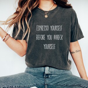 Puede incluir: Una camiseta gris oscuro con el texto "Espresso Yourself Before You Wreck Yourself" impreso en blanco.