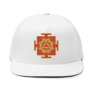 May include: White flat-brimmed cap featuring an embroidered geometric design in shades of orange, yellow, and pink. The design is centered on the front of the cap. The cap has a curved brim and a button on top.