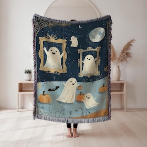 May include: A Halloween-themed woven throw blanket with a whimsical design. The blanket features friendly ghost characters, pumpkins, a bat, and a full moon against a dark blue starry night background. The blanket has a fringed edge, ideal for seasonal decor.