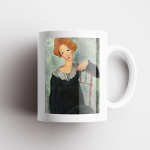 May include: A white ceramic mug with a colorful painting of a woman with red hair sitting in a chair. The woman is wearing a black dress with a white collar.
