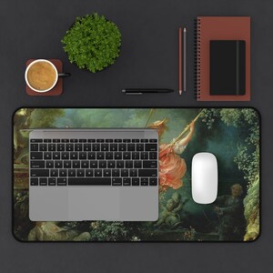May include: A mousepad featuring a vintage painting of a woman on a swing in a lush garden setting. The painting is in a muted color palette of greens, browns, and blues.