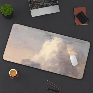 May include: A large, rectangular mouse pad with a soft, textured surface. The pad features a watercolor painting of a cloudy sky in shades of blue, gray, and white.