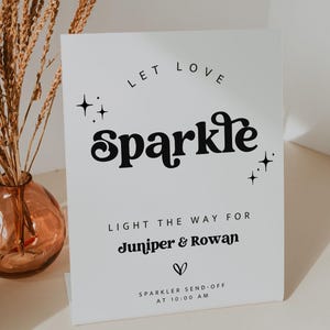 Könnte beinhalten: Ein weißes Schild mit schwarzem Text, der lautet: "Let love sparkle. Light the way for Juniper & Rowan. Sparkle send-off at 10:00 AM".
