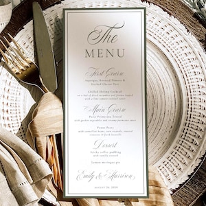 May include: A vertical white menu card with dark gray text and a thin olive green border, featuring the names Emily & Harrison and the date August 26, 2028. The menu lists courses including asparagus tart, shrimp cocktail, pasta, and dessert.