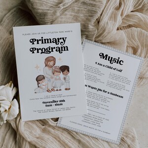 Könnte beinhalten: Zwei weiße Karten mit Text und Illustrationen, eine mit dem Titel "Primary Program" und die andere mit "Music". Die Programmkarte zeigt eine Zeichnung einer religiösen Figur mit Kindern. Die Karten liegen auf einem beigen Stoff.