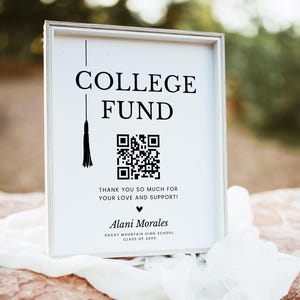May include: A framed sign with the words "COLLEGE FUND" in bold black letters. Below the text is a QR code and the message "THANK YOU SO MUCH FOR YOUR LOVE AND SUPPORT!" The sign includes a name and high school details.