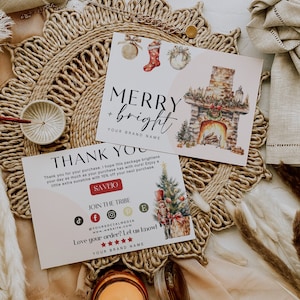Op de afbeelding: Twee kerstkaarten met aquarel illustraties. De eerste kaart zegt "Merry + Bright" met een illustratie van een open haard. De tweede kaart zegt "Bedankt" met een illustratie van een kerstboom en een notenkraker. Beide kaarten hebben een rode knop met de tekst "Bespaar 10% op je volgende aankoop".
