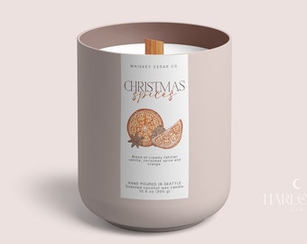 May include: A light pink candle jar with a white label that reads "WHISKEY CEDAR CO. CHRISTMAS spices" and features a drawing of orange slices and spices. The label also says "Blend of creamy vanilla, christmas spice and orange" and "HAND POURED IN SEATTLE Scented coconut wax candle 10.5 oz (300 g)".