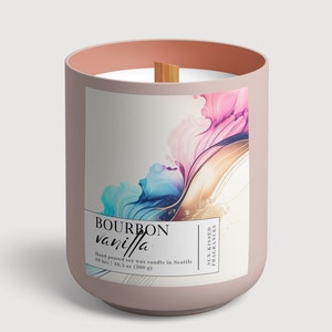 Puede incluir: Un tarro de vela rosa con una mecha de madera y una etiqueta que dice "BOURBON vanilla" y "Hand poured soy wax candle in Seattle 60 hrs | 10.5 oz (300 g)". La etiqueta tiene un diseño abstracto colorido con tonos rosas, azules y dorados.