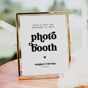 May include: A white ceramic mug with a black handle and the text "But First, Coffee" in a bold, black font. The mug is set against a blurred background, suggesting a cozy setting.