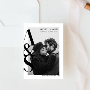 May include: A black and white wedding invitation with the text "Amelia & Samuel" and "Saturday 02 July 2022". The invitation features a black and white photo of a couple embracing.