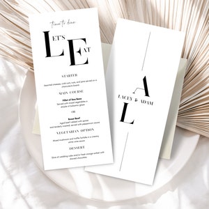 May include: A white wedding menu card with black text. The menu includes a starter, main course, vegetarian option, and dessert. The card also includes the text "Let's Eat" and "Time to Dine".