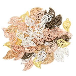 May include: A pile of decorative metal leaf charms in gold, silver, rose gold, and bronze colours. The leaves have a filigree design and are perfect for jewellery making or crafting.