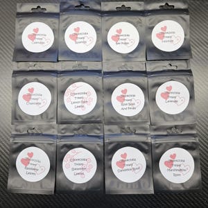 May include: Twelve small, clear plastic bags with white labels. Each label has a pink heart and text that reads "Chinchilla Treats" followed by a different flavor, such as "Rose Buds and Petals" or "Spearmint Leaves".