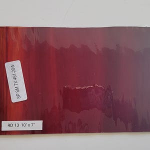 May include: A close-up of a red and purple gradient colored sheet of glass with the text "SP SM TX 451-20W" and "RD 13 10" x 7" printed on it.