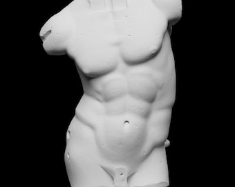Puede incluir: Una escultura de yeso blanco de un torso masculino, que muestra una musculatura detallada. La escultura está montada sobre una base rectangular y colocada sobre un fondo negro. El pecho, el abdomen y la parte superior de las piernas son visibles, con abdominales y músculos pectorales definidos.