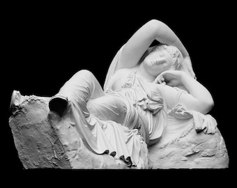 Puede incluir: Una escultura de mármol blanco de una mujer reclinada, con la cabeza apoyada en el brazo, con telas que fluyen alrededor de su cuerpo.