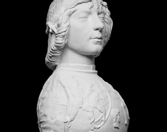 Pode incluir: Busto branco de uma pessoa com cabelo até aos ombros e uma peça de vestuário com gola alta. A escultura está sobre um fundo preto, realçando os detalhes do rosto e da roupa. O busto parece ser feito de gesso ou material semelhante.