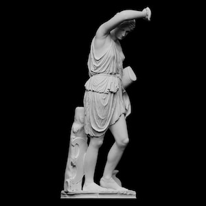 Puede incluir: Una estatua de mármol blanco de una mujer con una túnica fluida, sosteniendo una jarra en su mano derecha. La estatua está de pie sobre una base con un tronco de árbol detrás de ella.