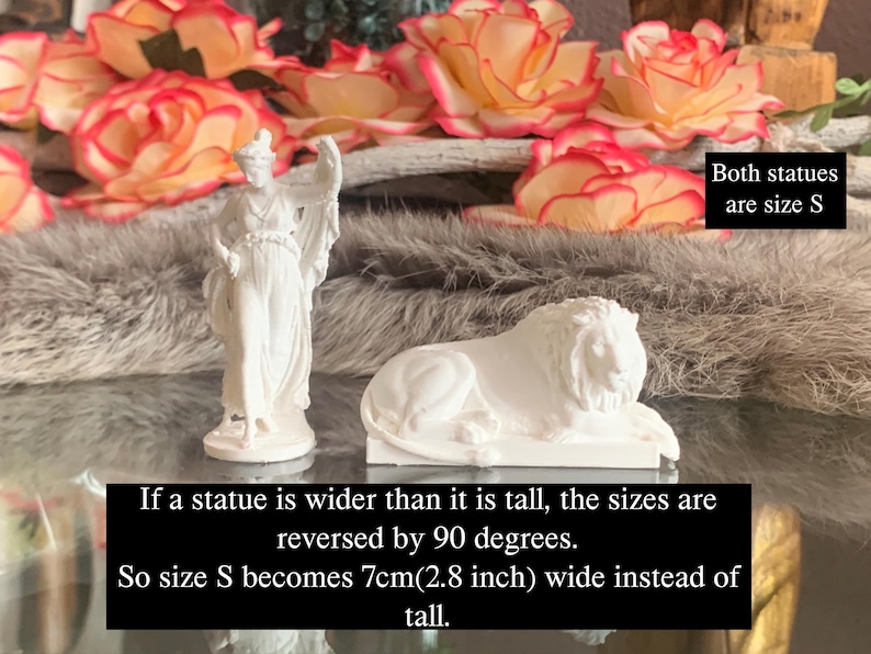 May include: Two white statues, a woman and a lion, are displayed on a fuzzy gray surface. Both statues are size S. The text below the statues reads: "If a statue is wider than it is tall, the sizes are reversed by 90 degrees. So size S becomes 7cm(2.8 inch) wide instead of tall."
