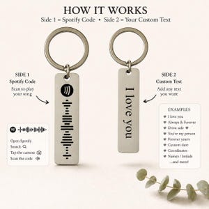 Op de afbeelding: Twee zilveren sleutelhangers. E&eacute;n heeft een Spotify-code, de andere zegt "I love you". De tekst "HOW IT WORKS" staat bovenaan. De afbeelding toont ook voorbeelden van aangepaste tekst.