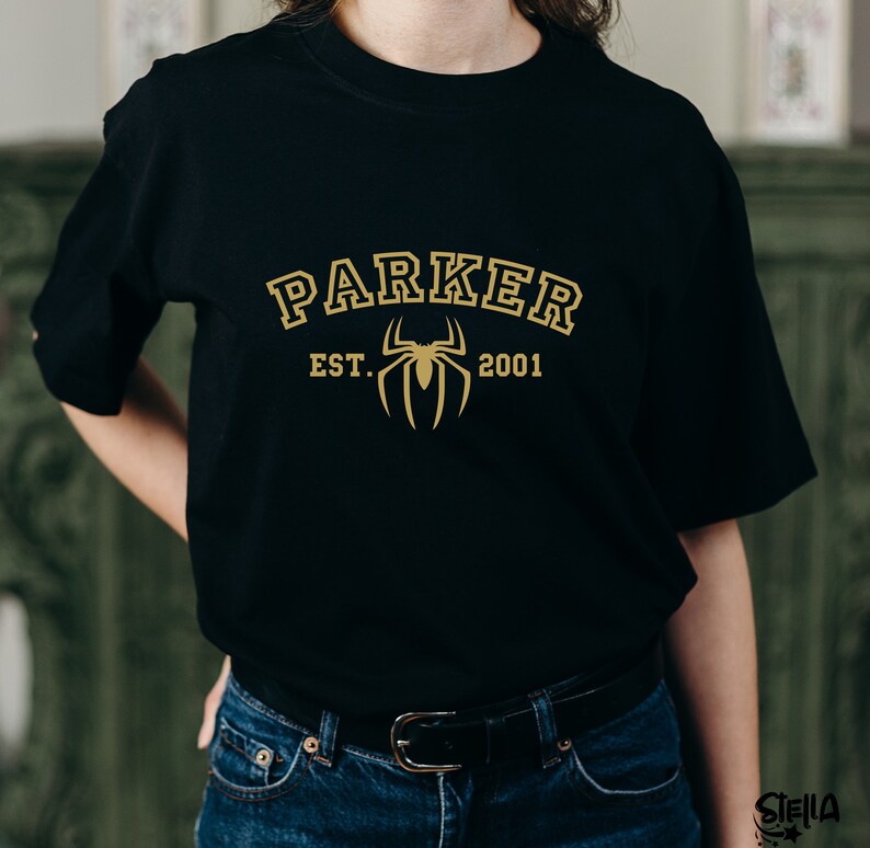 May include: Black t-shirt with a gold spider graphic and the text "PARKER EST. 2001" printed on the front.