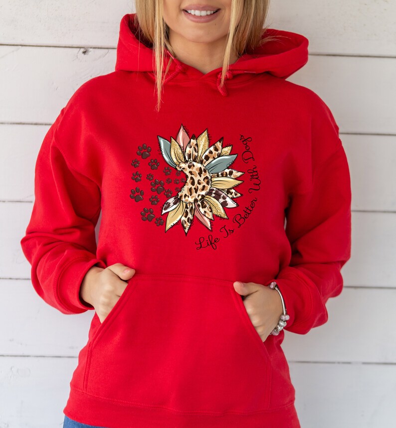 May include: Red hooded sweatshirt with a sunflower design featuring a leopard print and paw prints. The text "Life Is Better With Dogs" is printed on the sweatshirt.