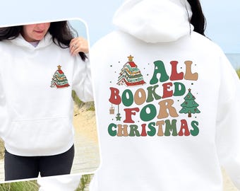 May include: White hoodie with a front pocket and a Christmas tree graphic. The back displays the text "ALL BOOKED FOR CHRISTMAS" in a retro font, with Christmas tree and gift graphics. A festive winter garment.