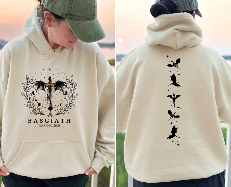 May include: A cream coloured hoodie with a black dragon graphic on the front and five black dragons on the back. The front graphic includes the text "BASGIATH WAR COLLEGE".