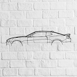 May include: Black line drawing of a coupe car on a white brick wall. The car's outline shows the hood, roof, doors, and rear spoiler. The wheels are also visible. The artwork is a minimalist design.