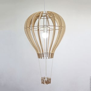 May include: A wooden hot air balloon pendant light fitting with a light bulb inside. The balloon is suspended from the ceiling by a cord and has a small wooden basket underneath.