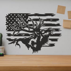 May include: Black and white silhouette of an elk with antlers, with the American flag in the background. The elk is facing right and has its mouth open, as if it is calling. The flag is distressed and has a rustic look.