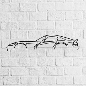 Puede incluir: Dibujo lineal negro de un coche deportivo sobre una pared de ladrillos blancos. El diseño minimalista muestra la carrocería, las ruedas y las ventanas. Una obra de arte sencilla y elegante para los amantes de los coches.