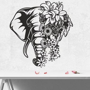 May include: Black and white silhouette of an elephant's head with a floral crown of lilies, roses, and other flowers.
