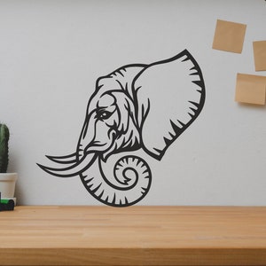 May include: Black and white silhouette of an elephant's head with its trunk curled up. The image is on a white wall with a wooden shelf below it.