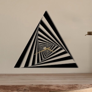 Könnte beinhalten: Eine schwarze und weiße dreieckige Wanduhr mit einem wirbelnden, optischen Täuschungsdesign. Die Uhrzeiger sind golden.