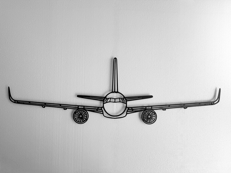 May include: Black metal airplane wall art. The artwork depicts a stylized airplane with wings, a fuselage, and two engines. The design is a minimalist outline, suitable for aviation enthusiasts or modern decor.