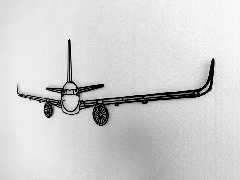 May include: Black metal airplane wall art. The artwork features a detailed outline of an airplane, including the fuselage, wings, tail, and wheels. The design is mounted on a white wall, creating a striking contrast.