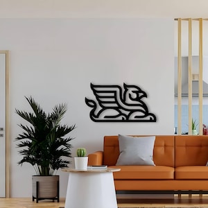 Pode incluir: Arte de parede de metal preto com um design estilizado de um grifo, uma criatura m&iacute;tica com a cabe&ccedil;a e as asas de uma &aacute;guia e o corpo de um le&atilde;o. A arte est&aacute; montada em uma parede branca em um ambiente de sala de estar.