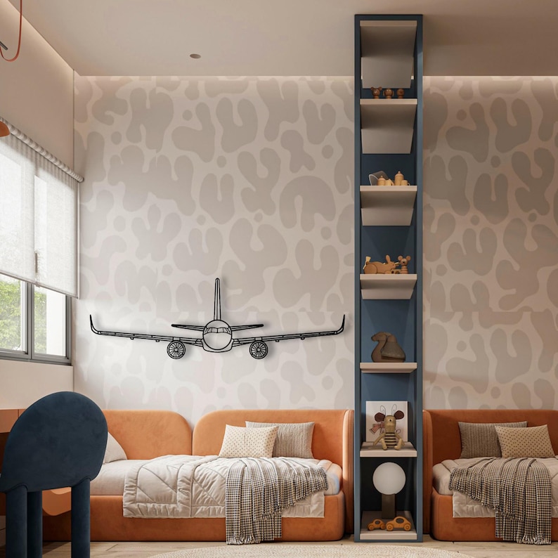 May include: A black metal airplane wall art decorates a child's bedroom. The room features orange beds, a blue bookshelf, and a patterned wallpaper. The airplane is mounted on the wall above the bed.