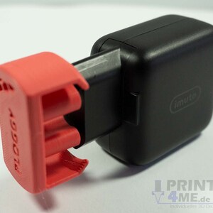 Könnte beinhalten: Ein rotes 3D-gedrucktes Gehäuse für ein schwarzes Netzteil mit dem Wort "imuto" auf dem Netzteil.